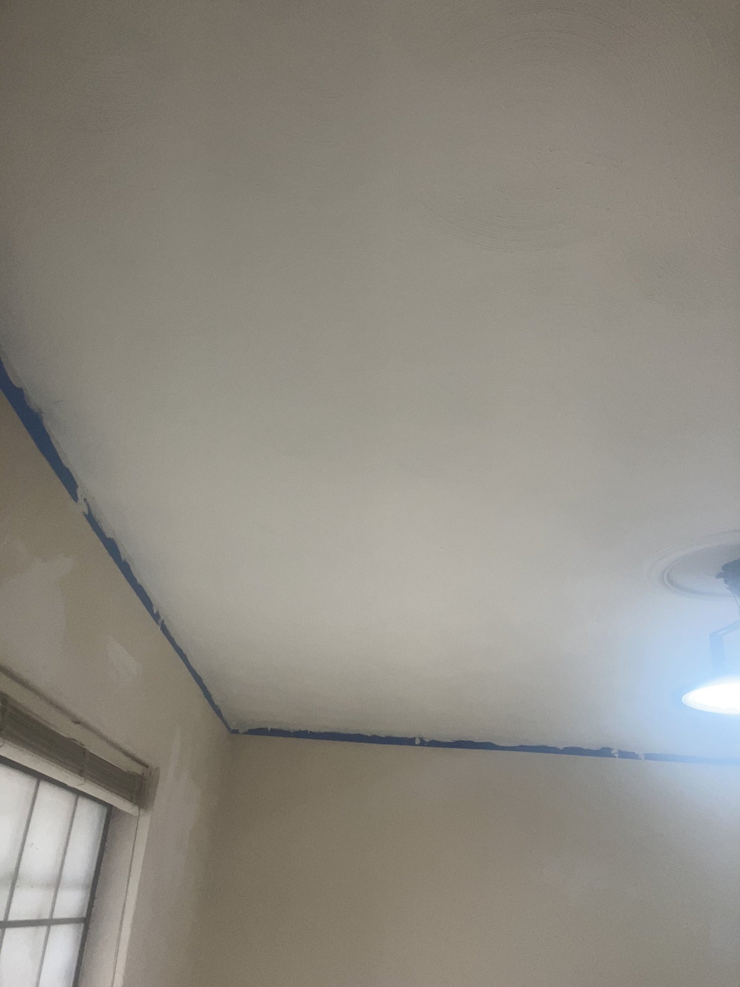 A ceiling after drywall work, ready for the last coat of paint.